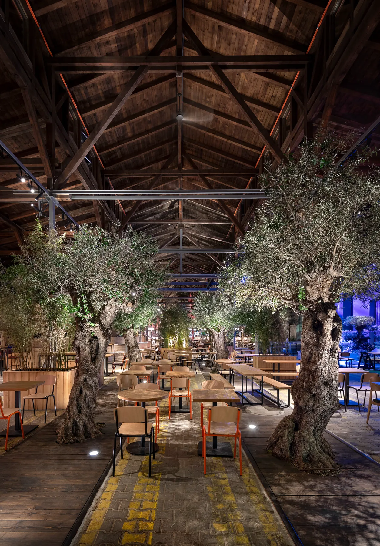 Vertical garden restaurant view with tree canopy and dining tables.