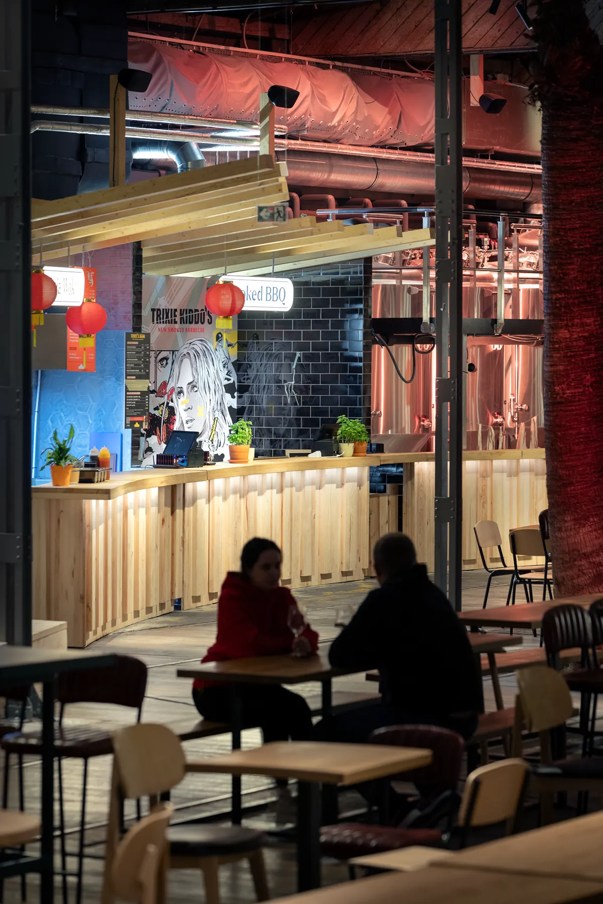 Vertical hospitality interior detail with intimate lighting and dark surfaces.